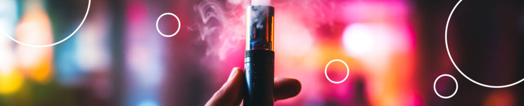 mão segurando um cigarro eletrônico saindo vapor em um fundo colorido.